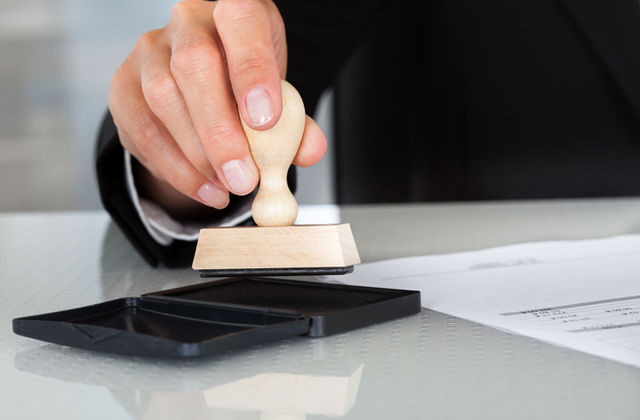 Notary public applying a stamp to a document